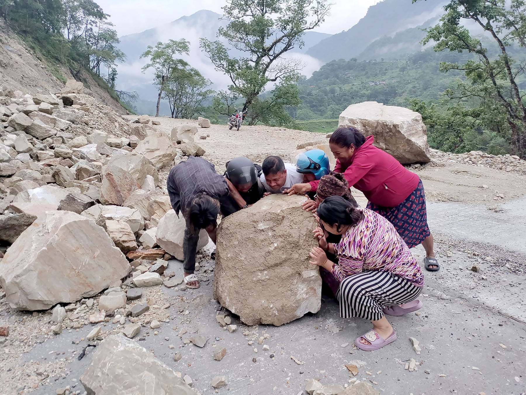 अवरुद्ध सडक खुलाउन ढुङ्गा हटाउँदै