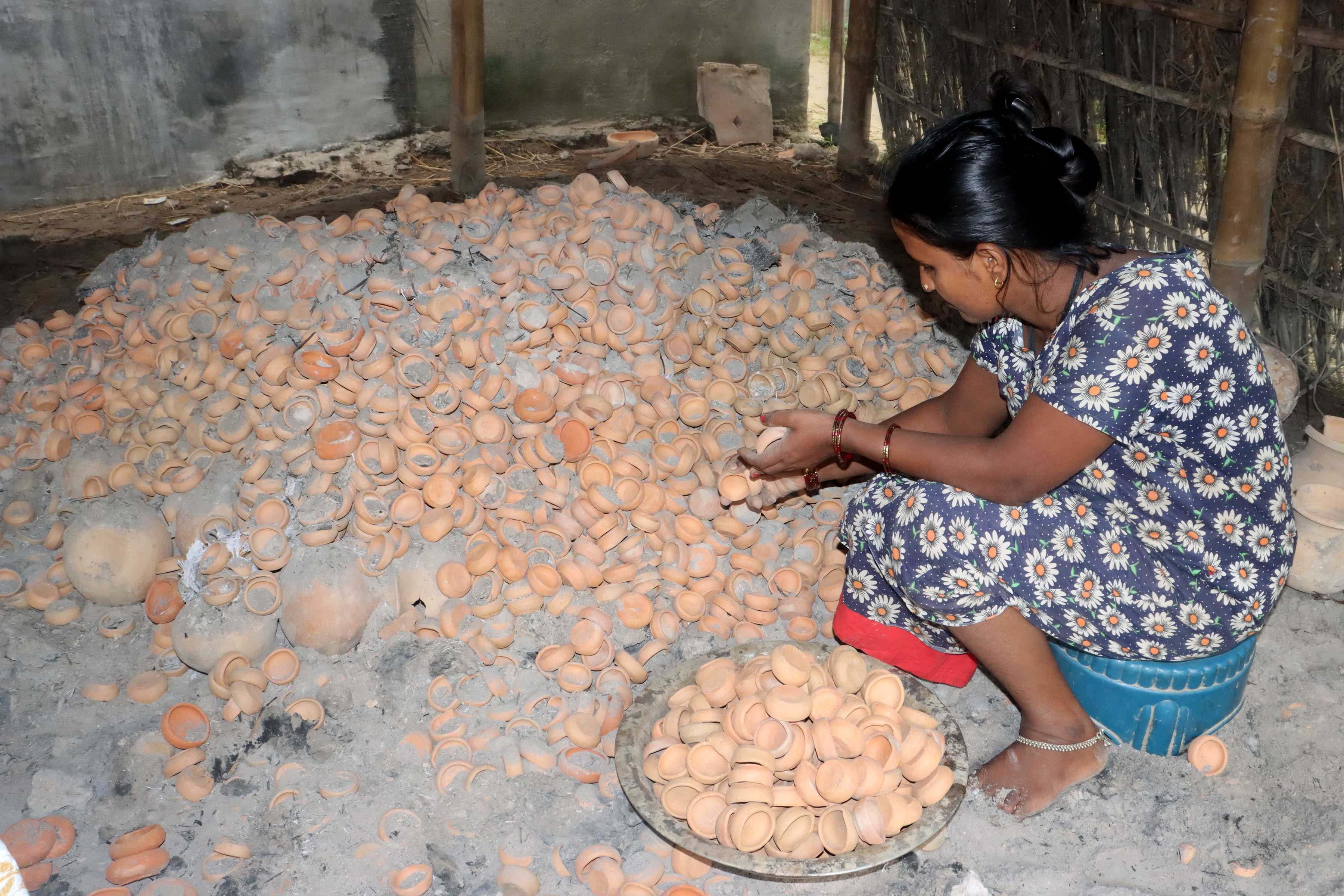 भट्टीमा पोलेको माटाको दियो निकालिँदै